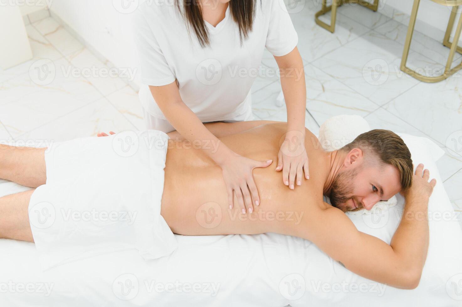 Handsome man receiving massage at spa photo
