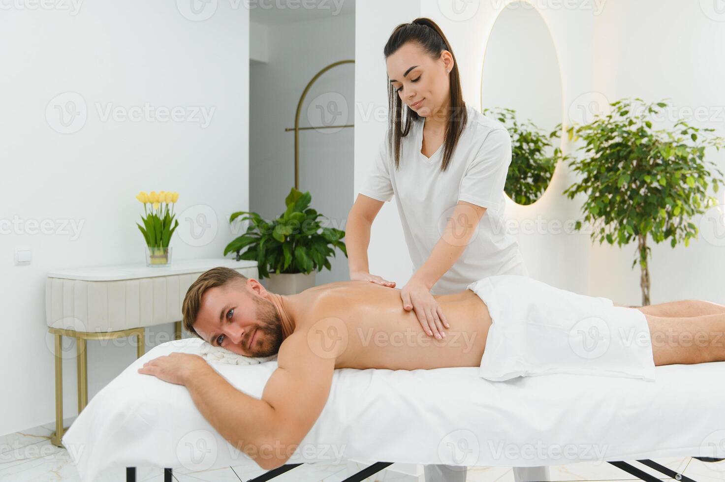 Handsome middle-aged man enjoying relaxing spa massage with oils photo