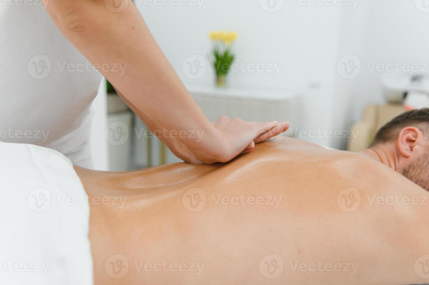 Young man is enjoying massage on spa treatment photo