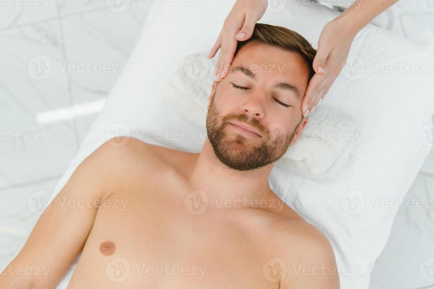 Handsome middle-aged man enjoying relaxing spa massage with oils photo