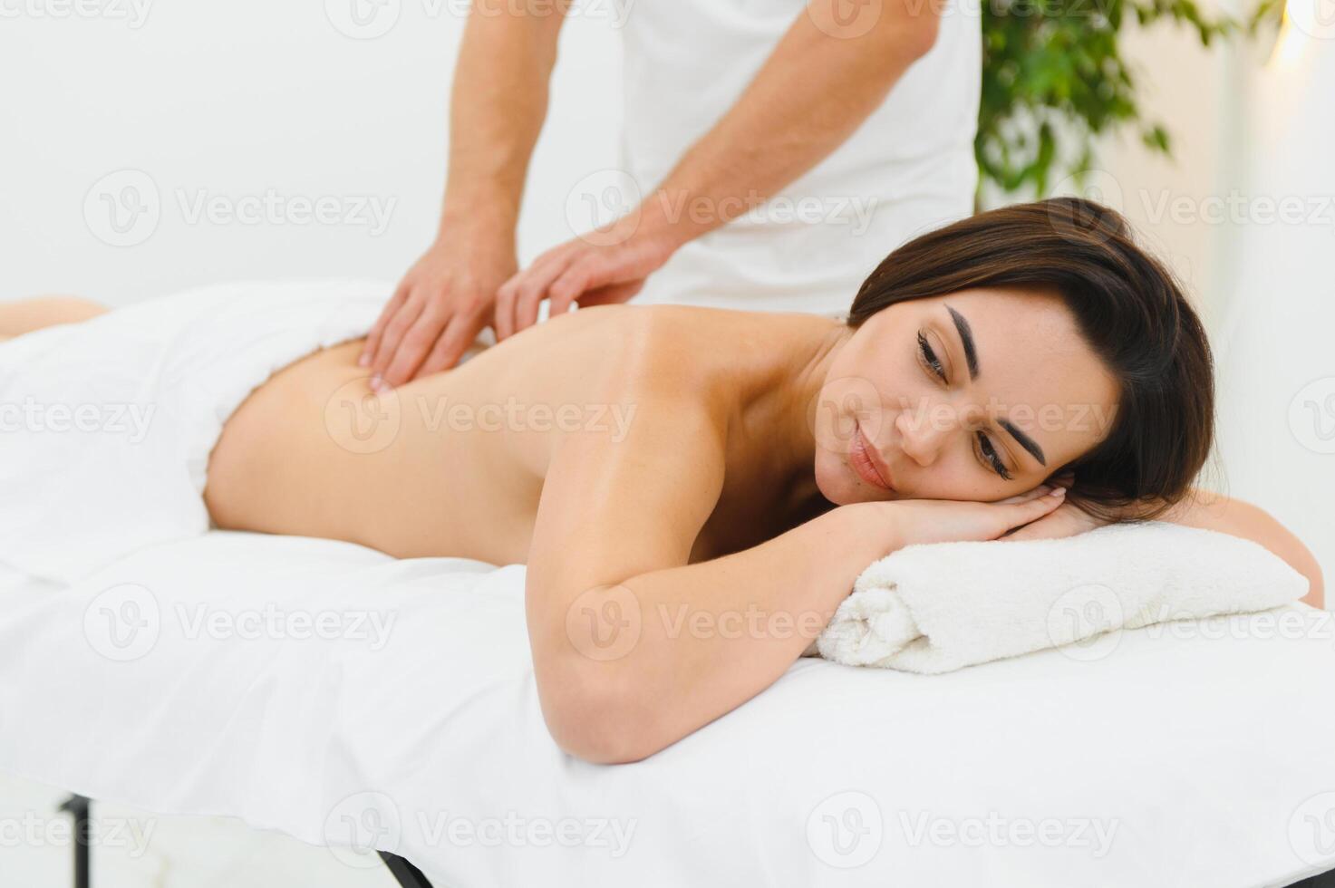 Spa therapy. Beautiful young woman lying on table during massage in salon, closeup photo