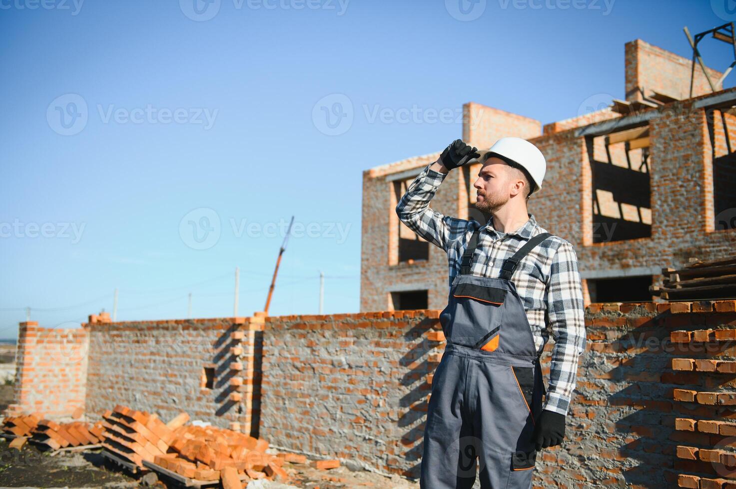 construction mason worker bricklayer installing red brick with trowel putty knife outdoors photo