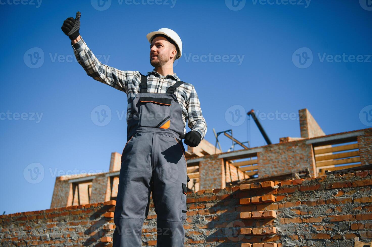 Installing brick wall. Construction worker in uniform and safety equipment have job on building photo