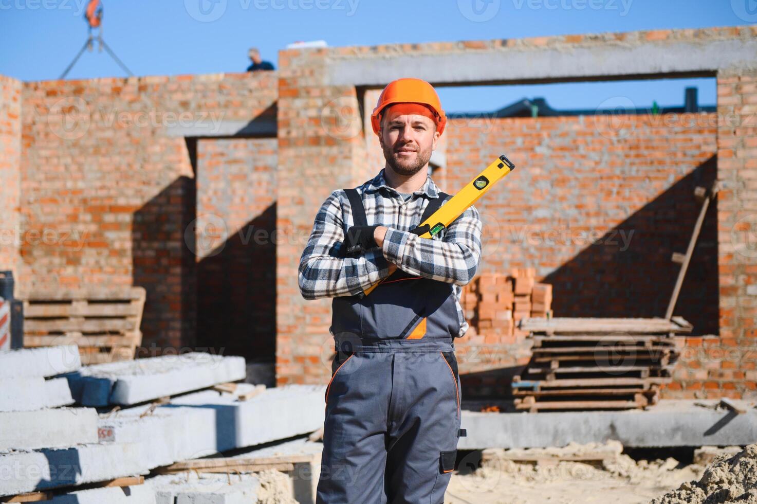 Installing brick wall. Construction worker in uniform and safety equipment have job on building photo