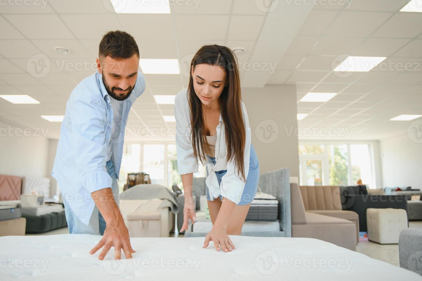 A young couple is choosing bedding at a bed, mattress and pillow store. Everything for a comfortable sleep photo