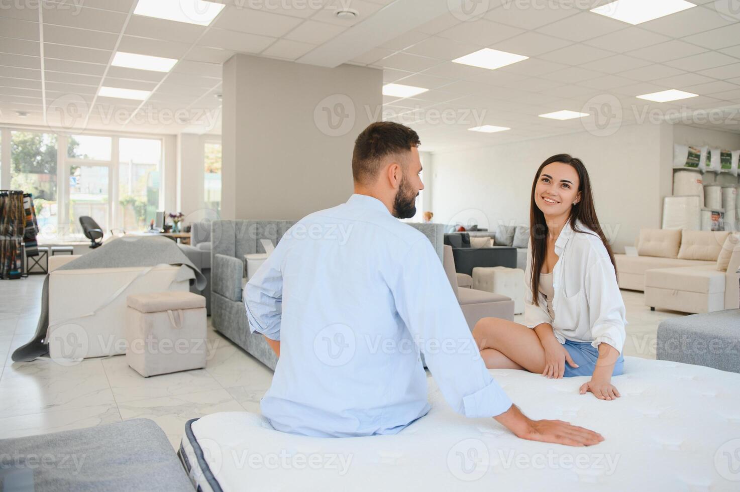 A young couple is choosing bedding at a bed, mattress and pillow store. Everything for a comfortable sleep photo