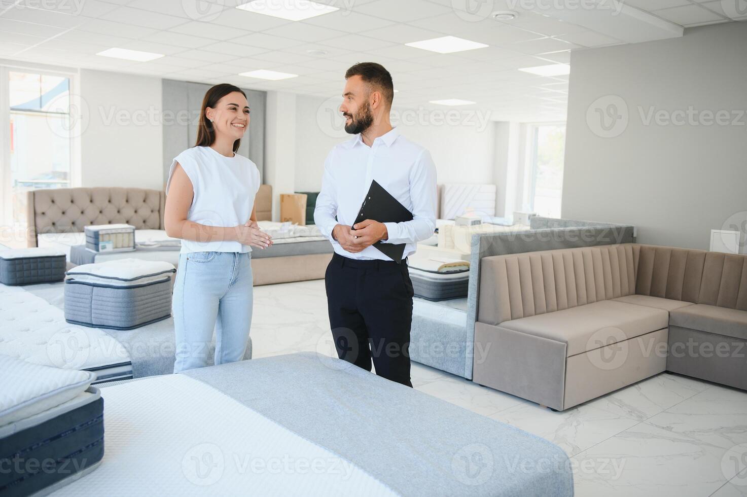 A professional sales consultant advises a client in a furniture store. photo