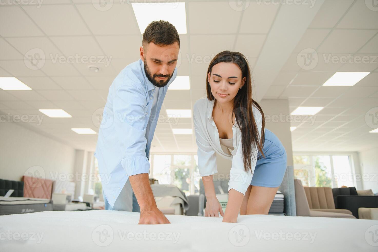 A young couple is choosing bedding at a bed, mattress and pillow store. Everything for a comfortable sleep photo