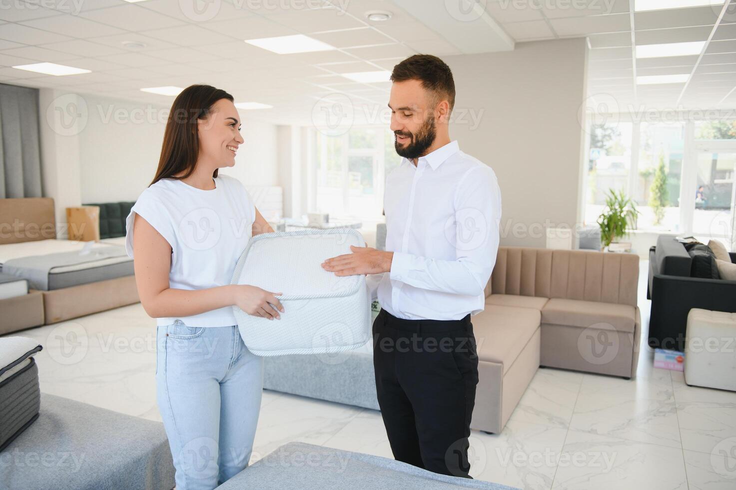 Salesman explaining to woman customer at furniture store photo