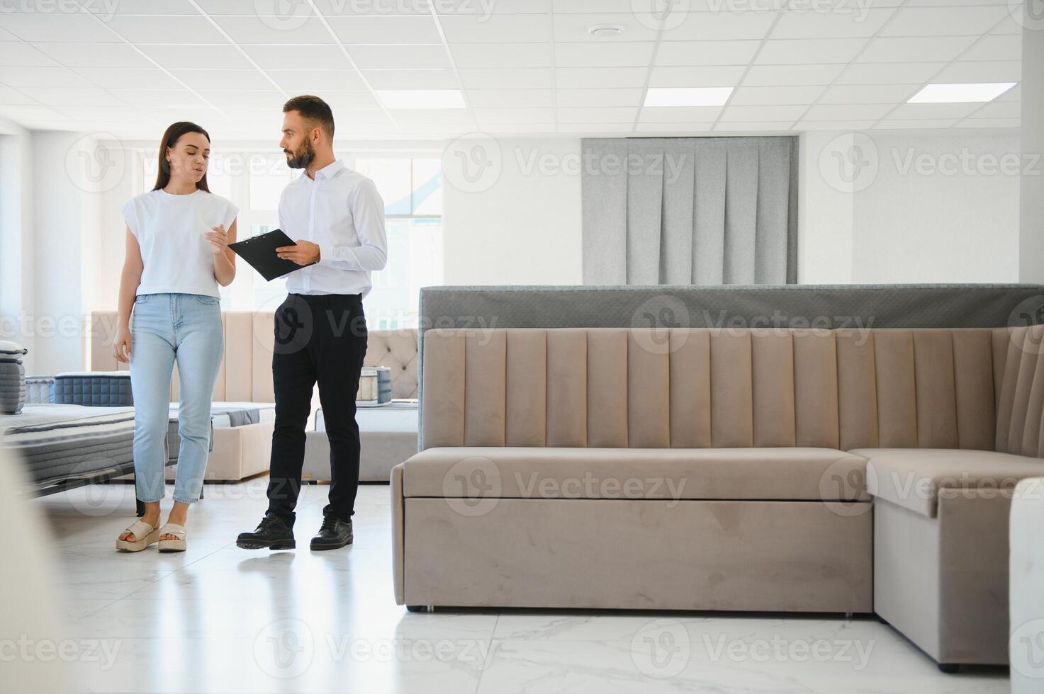 A professional sales consultant advises a client in a furniture store. photo