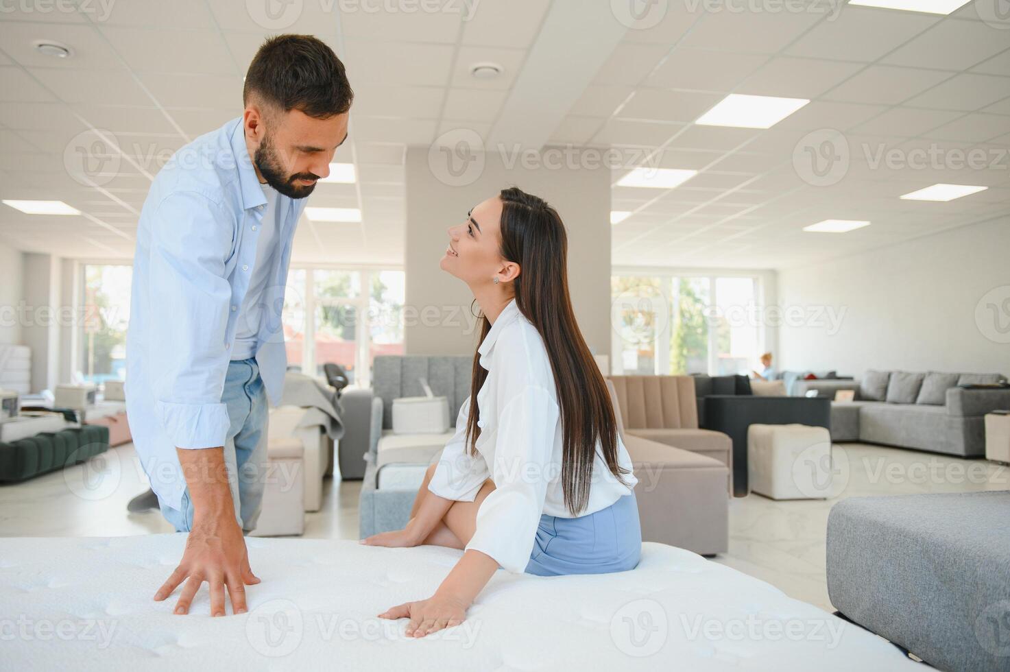 A young couple is choosing bedding at a bed, mattress and pillow store. Everything for a comfortable sleep photo
