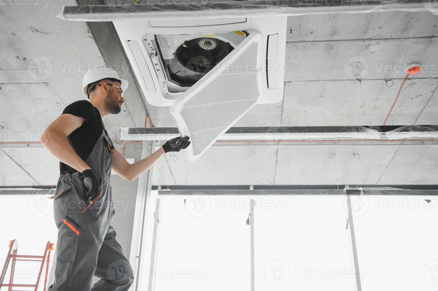 Happy Male Technician Repairing Air Conditioner photo