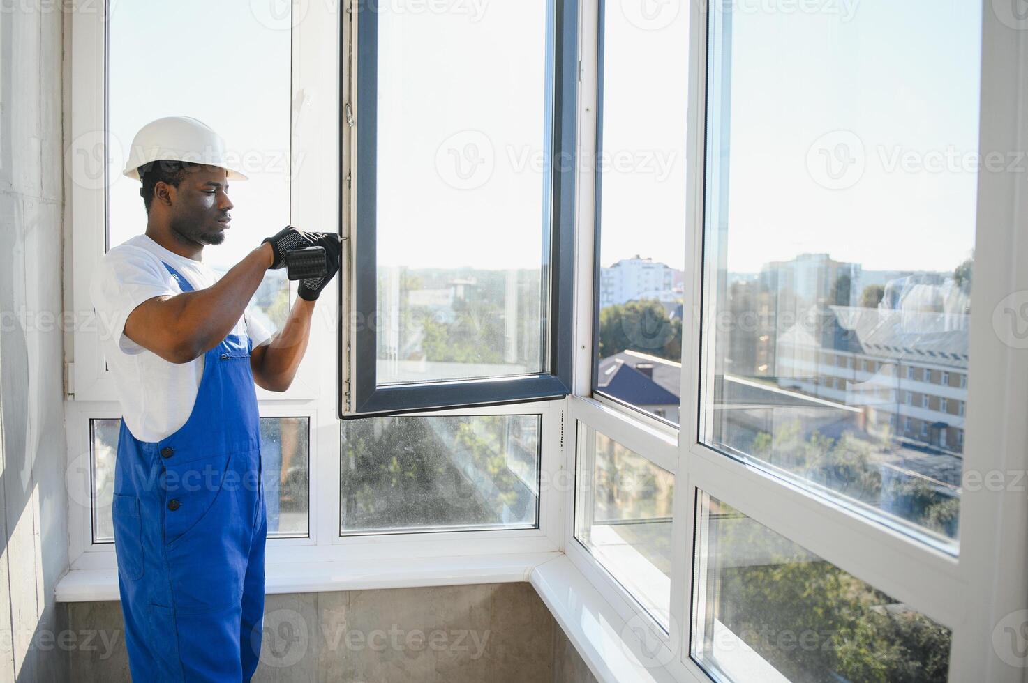 handsome young man installing bay window in new house construction site photo