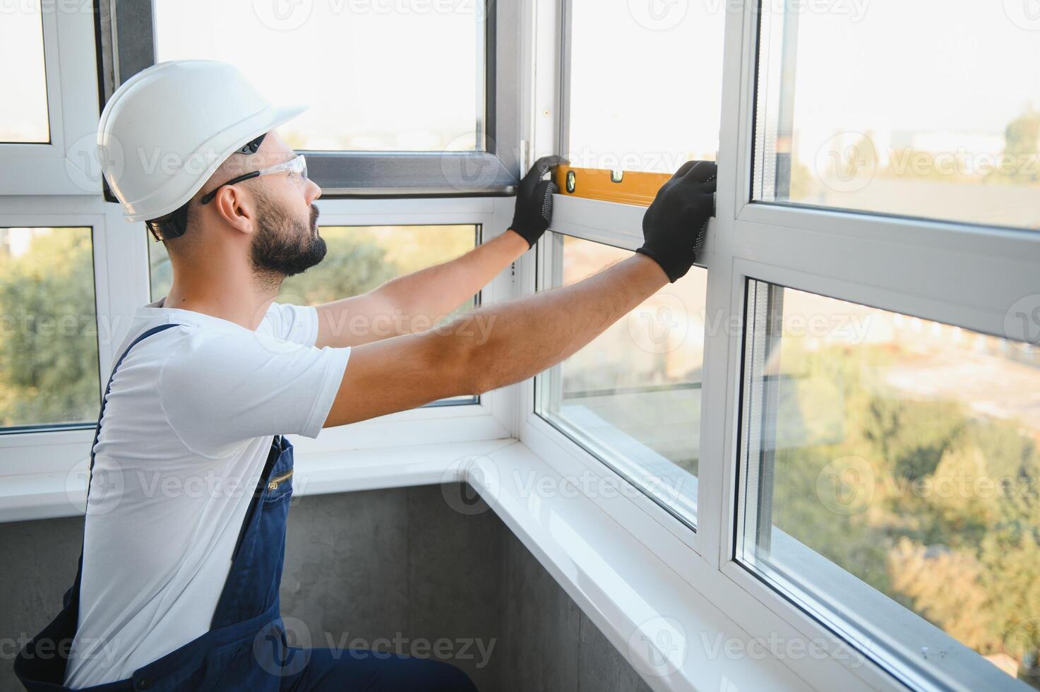 Worker installing plastic window indoors photo