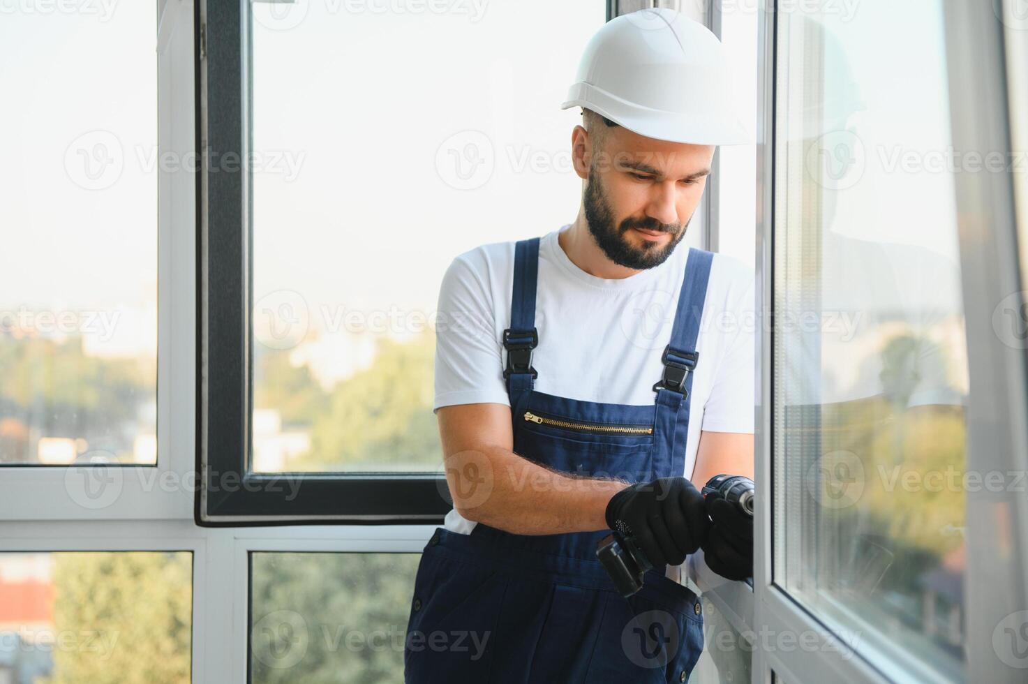 Worker installing plastic window indoors photo