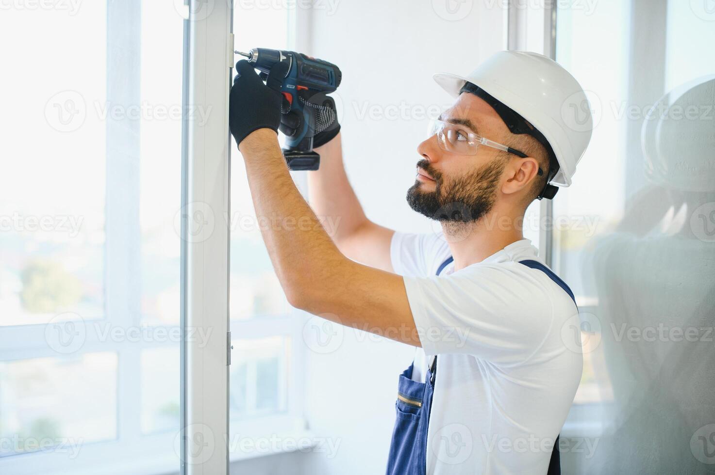 Worker installing plastic window indoors photo