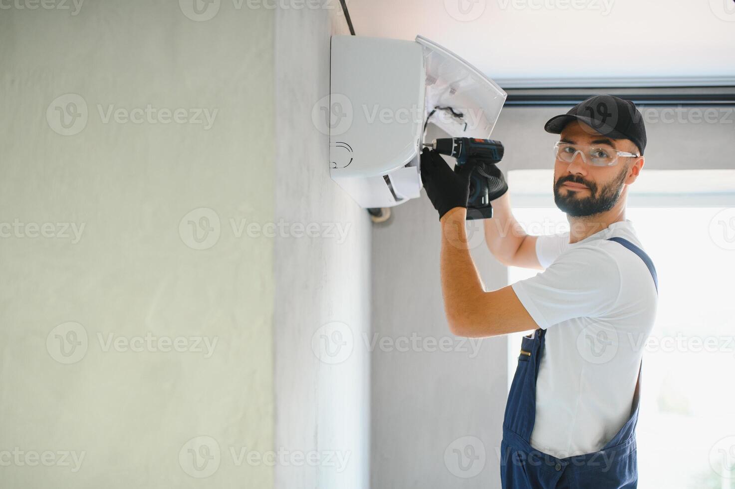 Repairman fix air conditioning systems, Male technicians service for repair and maintenance of air conditioners, Air conditioning technicians install new air conditioners in homes photo