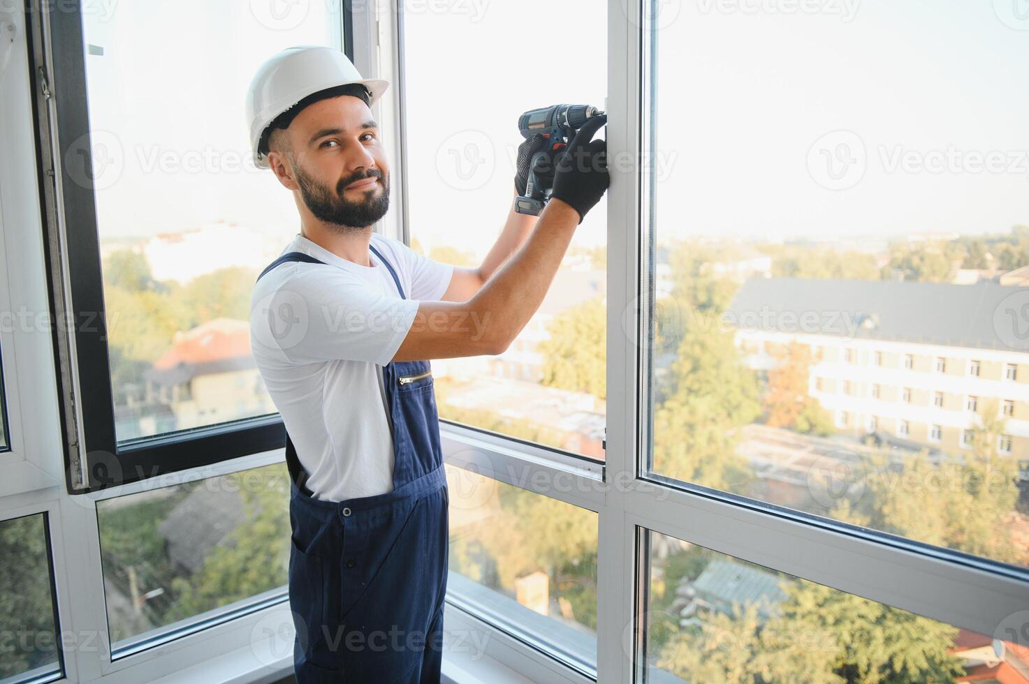 Worker installing plastic window indoors photo