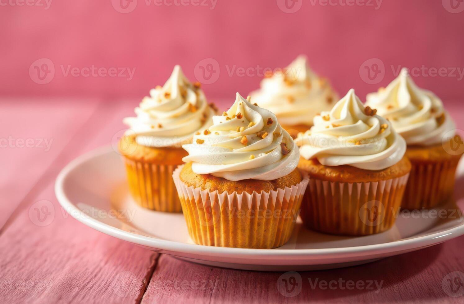 Delicious vanilla cupcakes with creamy frosting and sprinkles on pink background photo