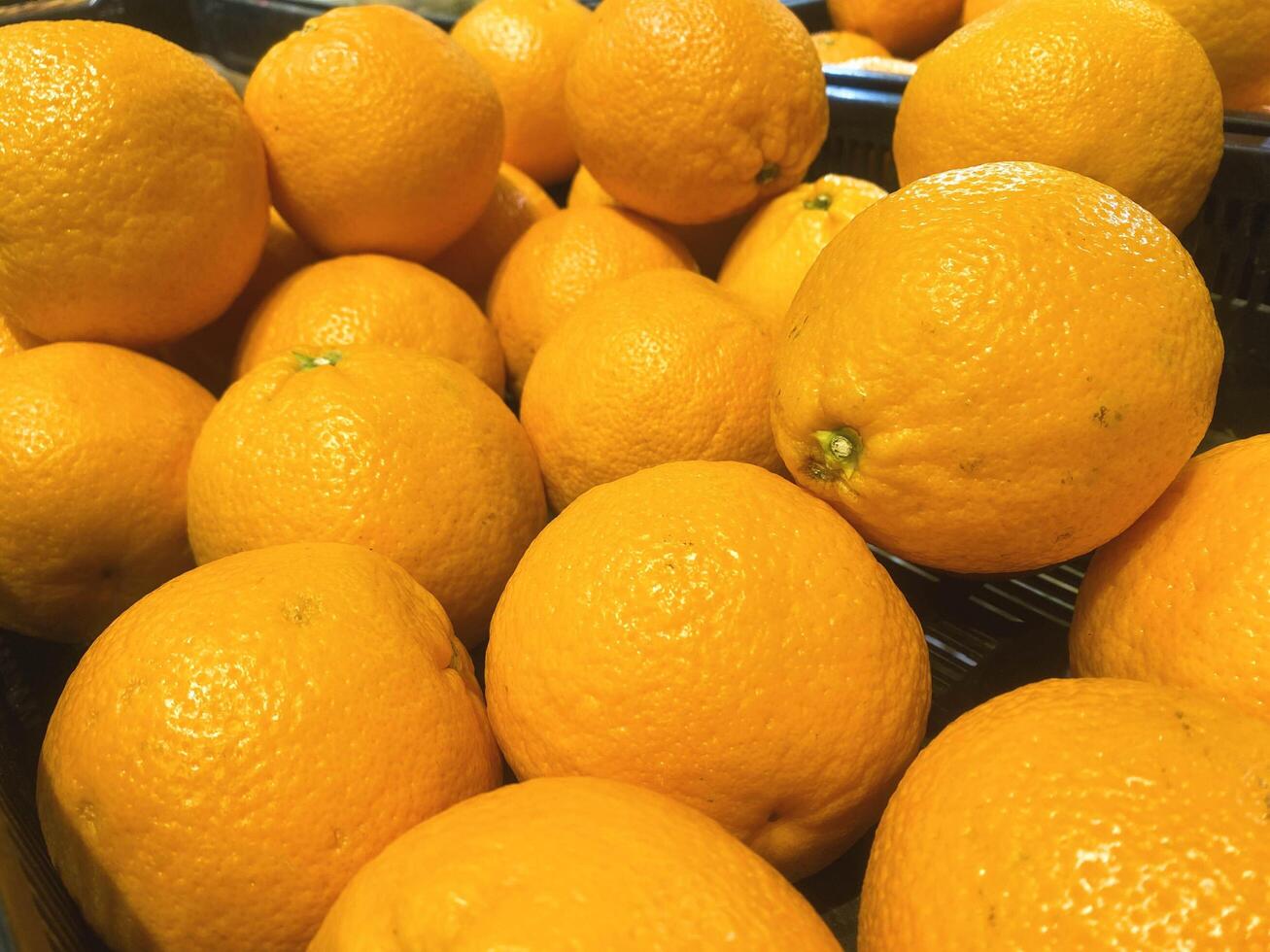 A stack of oranges displayed at the market or grocery store photo