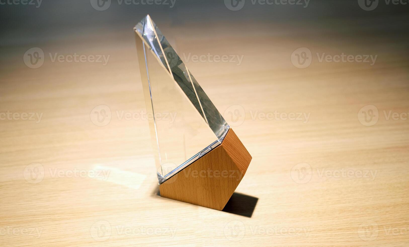 Business award made of glass and wood on a table with spotlights photo