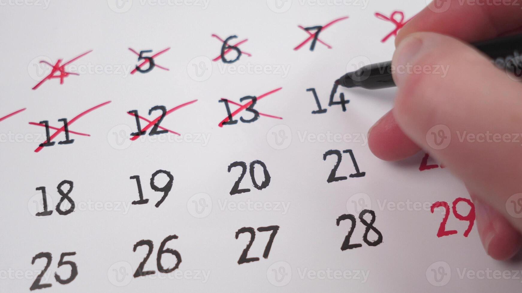 A hand marking important dates on a calendar, showing essential time management and organization skills for success photo
