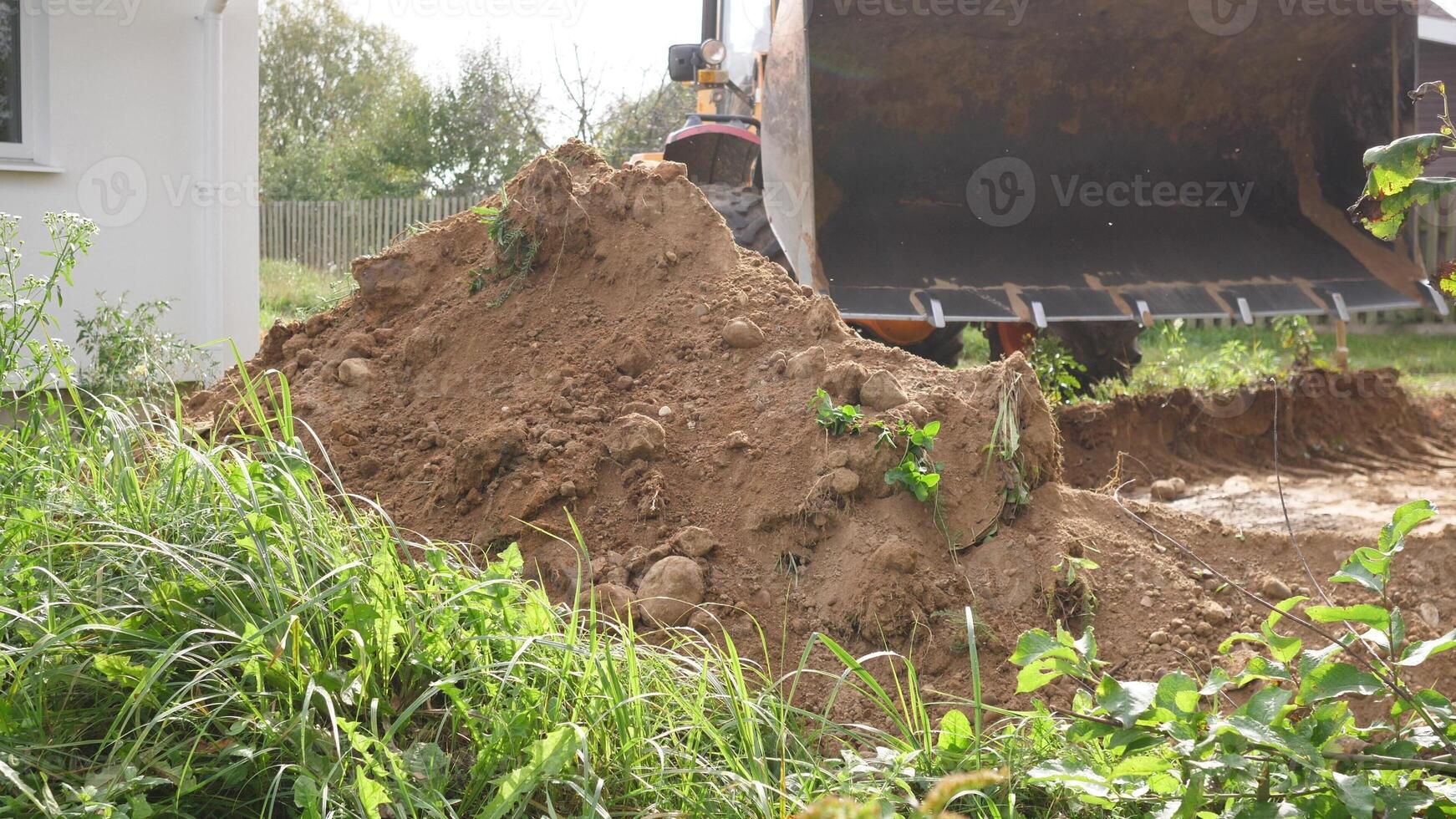 A busy construction site showcasing a massive dirt pile along with machinery meant for excavation and digging work photo