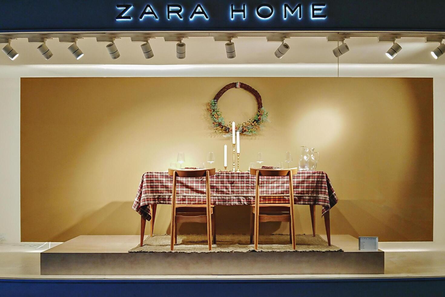 Qormi, Malta-6.12.2021 - Festive Dining Table with Candles and Wreath Against Neutral Background in Zara Home Display photo