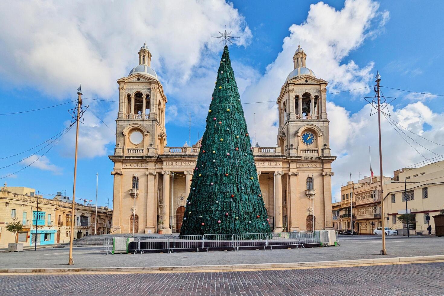 Paola, Malta,16.12.2024 - Christmas Tree in Front of Twin Bell Towers of Historic Christ the King Church in Malta photo