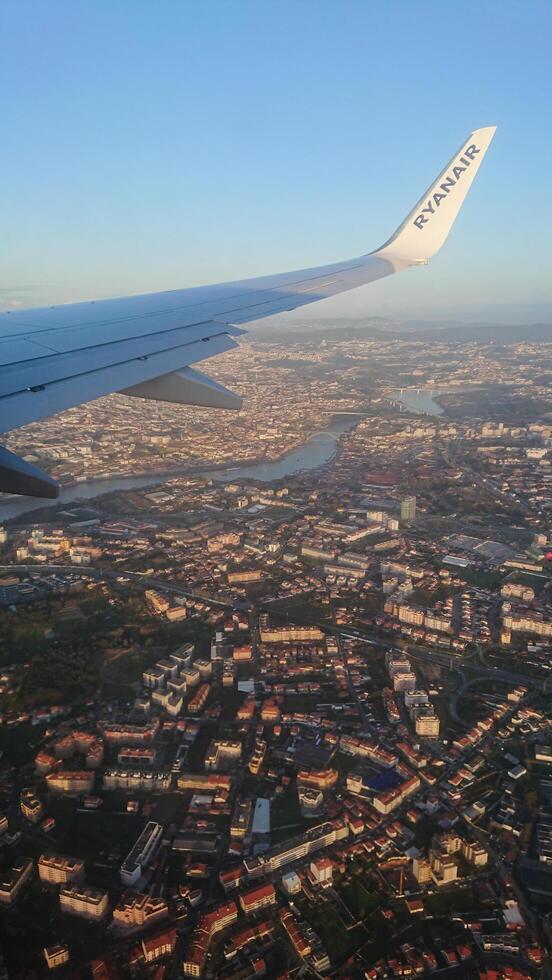 Bratislava, Slovakia-9.01.2020. Ryanair airplane wing soaring above Bratislava, Slovakia, showcasing Danube River and urban landscape glowing under golden sunset photo