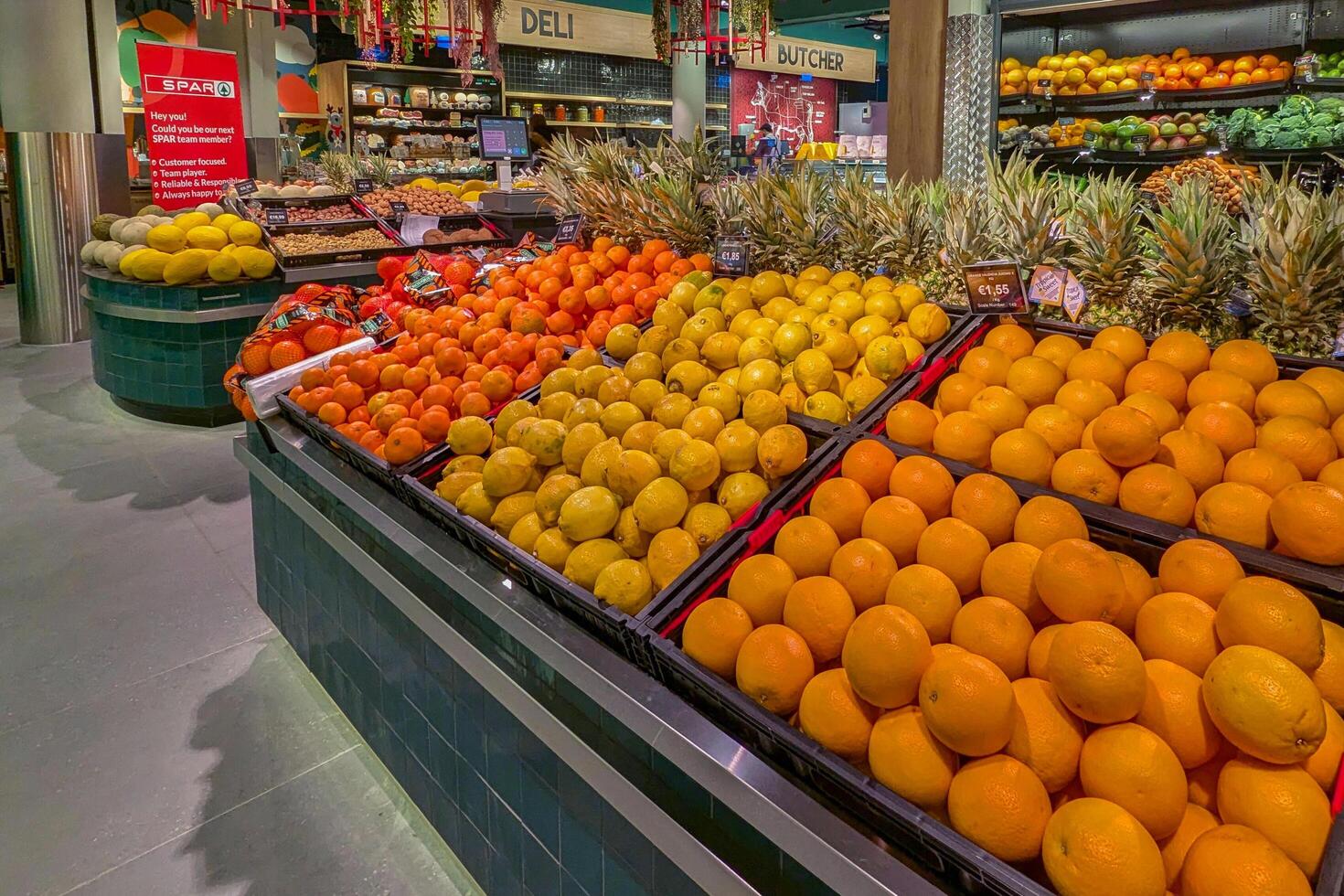 Marsaskala, Malta -15.12.2024. Assorted fresh oranges, lemons, and pineapples neatly displayed at a colorful grocery store fruit section photo