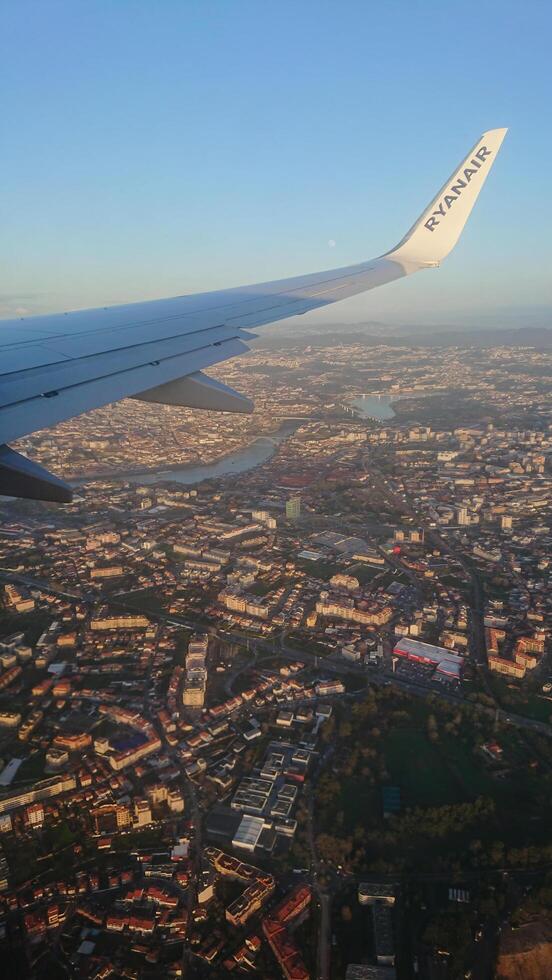 Bratislava, Slovakia-9.01.2020. Ryanair airplane wing soaring above Bratislava, Slovakia, showcasing Danube River and urban landscape glowing under golden sunset photo