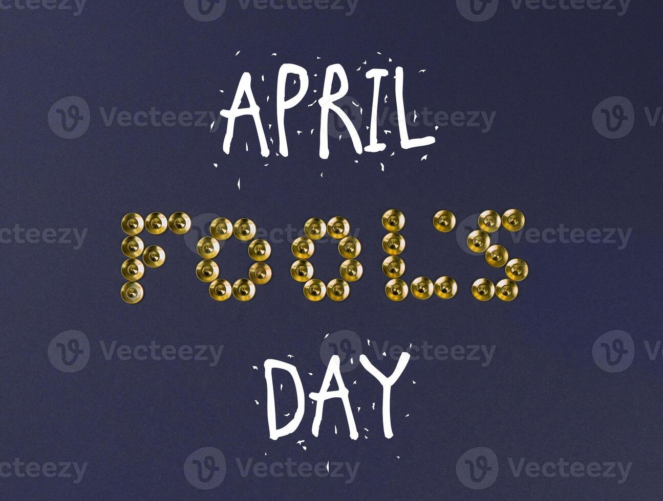 April Fools Day Text Design With Gold Push Pins on Dark Blue Background With Copy Space photo