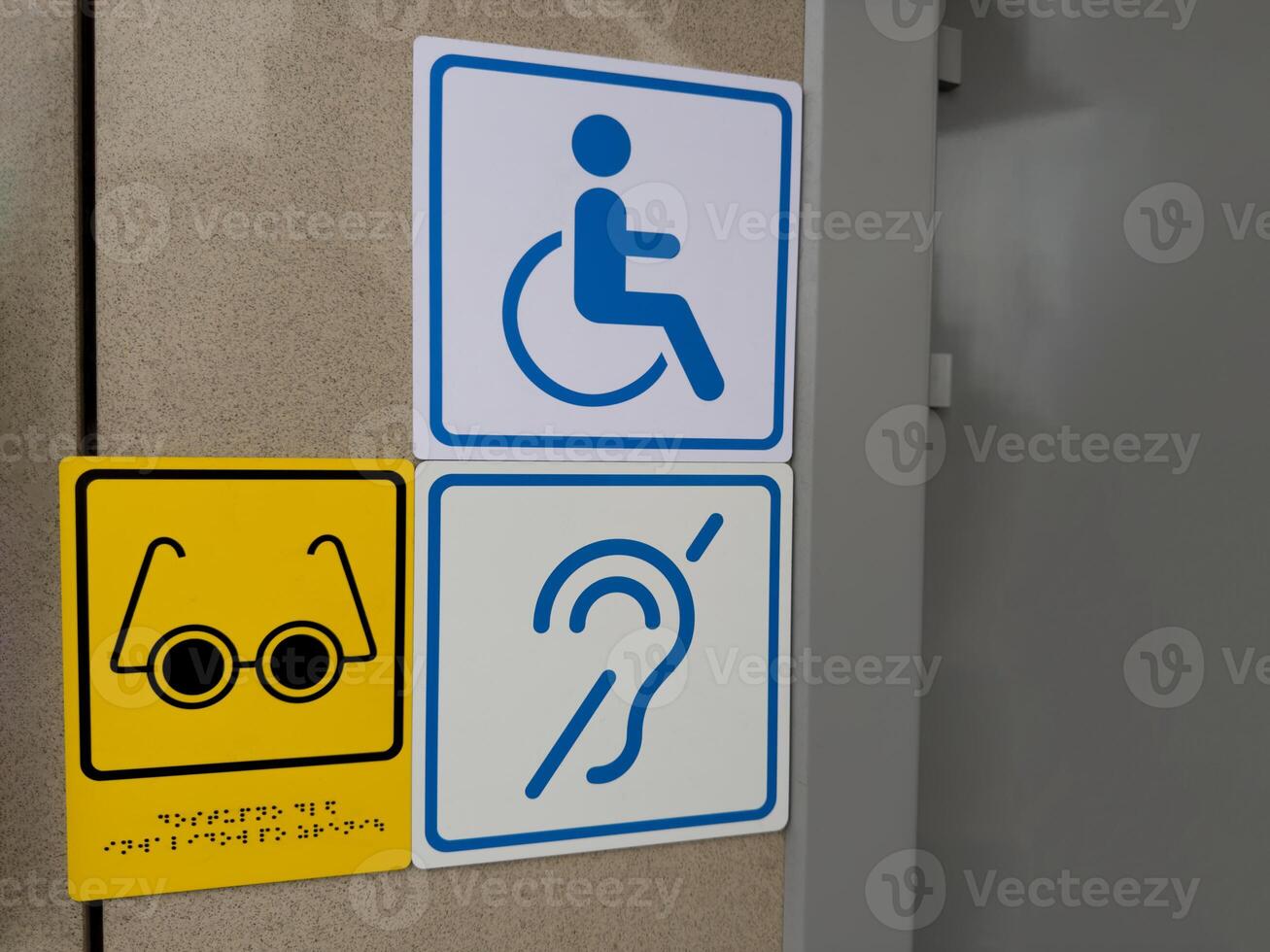 Icon of deaf person and person with limited vision with braille text on wall photo