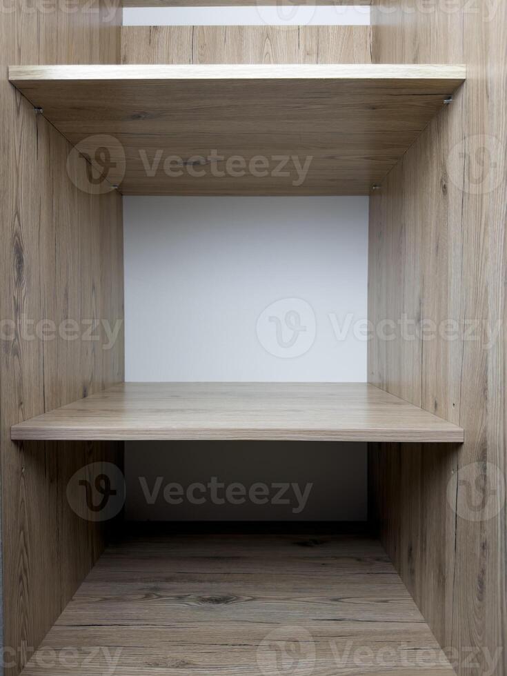 Empty shelf of wardrobe with place for clothes, shelf of wooden wardrobe without things, empty place for household items, vertical photo of shelves of spacious closet in interior of house
