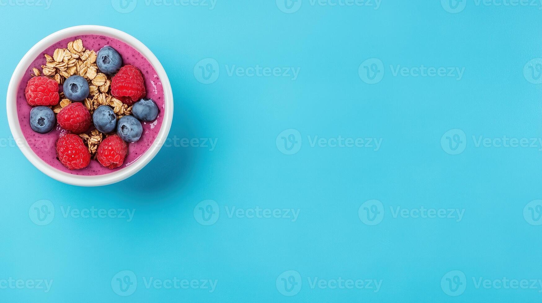 Vibrant Acai Bowl with Fresh Fruits and Granola on Blue Background for Healthy Lifestyle Concept photo