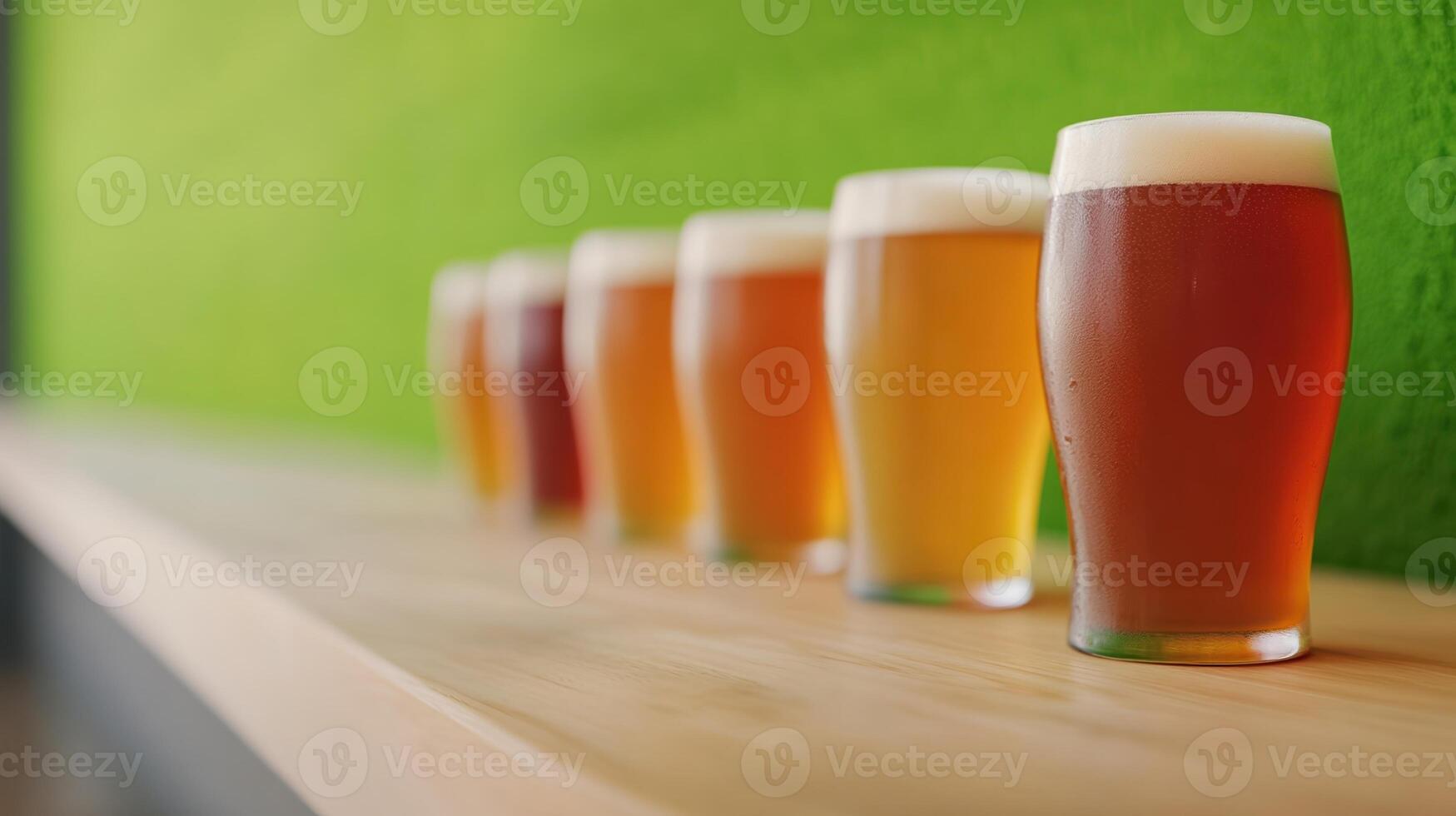 Row of craft beer glasses with varying colors on a wooden bar. Focus on foreground glass with green background. Concept of beer tasting and brewing. photo