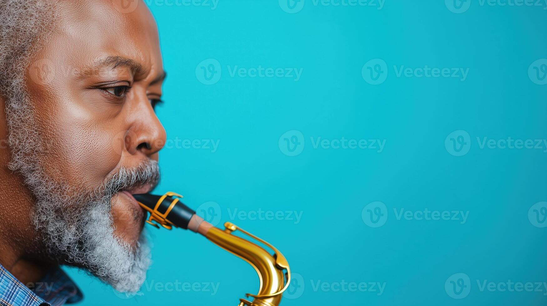 Close Up of Man Playing Saxophone Looking Away on Bright Blue Background for Music Concept and Instrumental Theme in Vibrant Color Scheme with Artistic Composition and Copy Space Idea photo