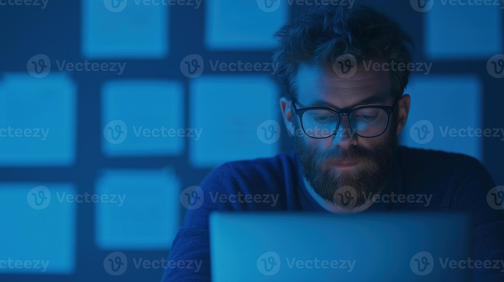 Entrepreneur Working Late at Night in Dimly Lit Office with Laptop and Blue Light Setting photo