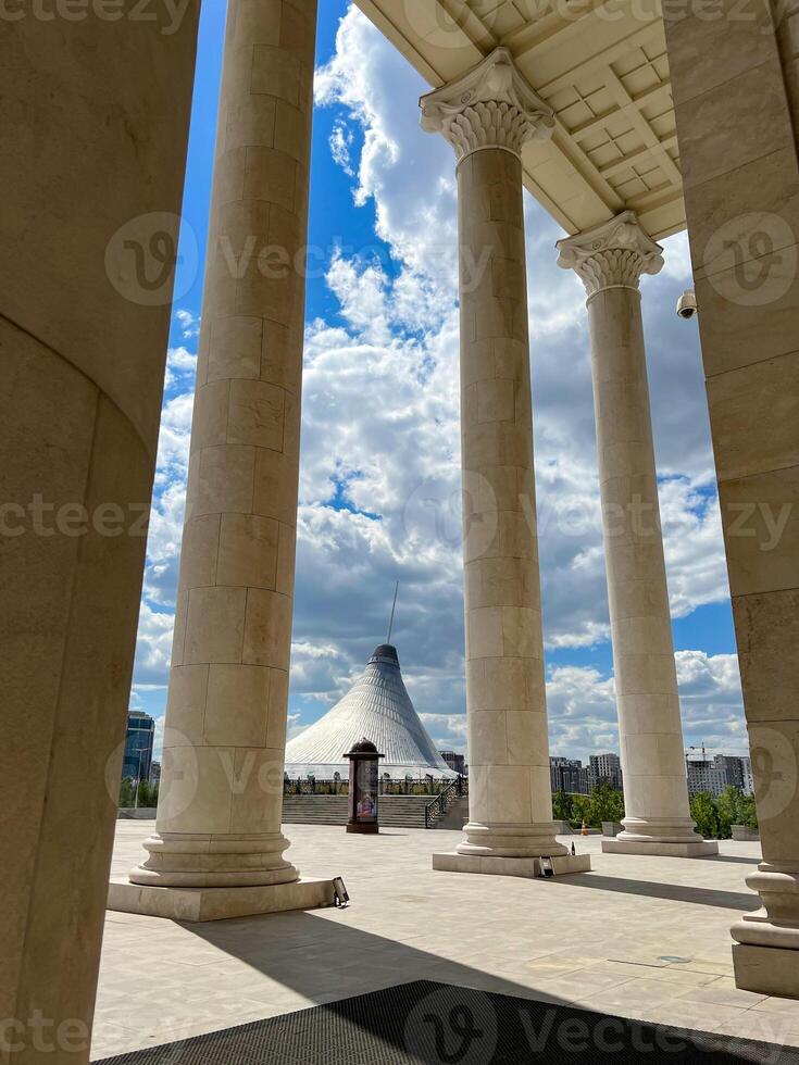 View of Khan Shatyr through the columns of State Opera and Ballet Theatre in Astana photo
