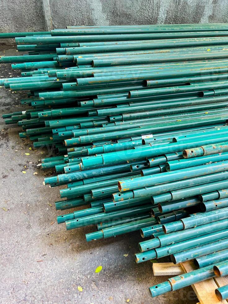 Turquoise pipes stacked on the ground photo