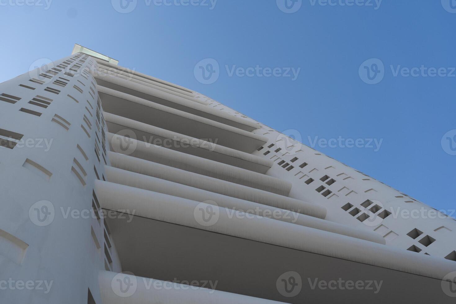 Tall modern white skyscraper under sky photo