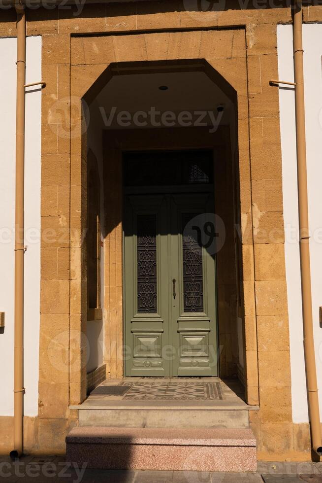 House facade with Mediterranean styled green door photo