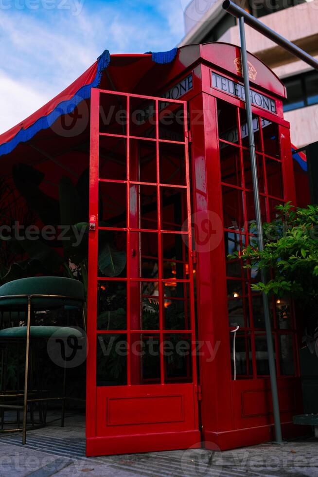 Traditional now extinct old red telephone box from England in Cypriote cafe photo