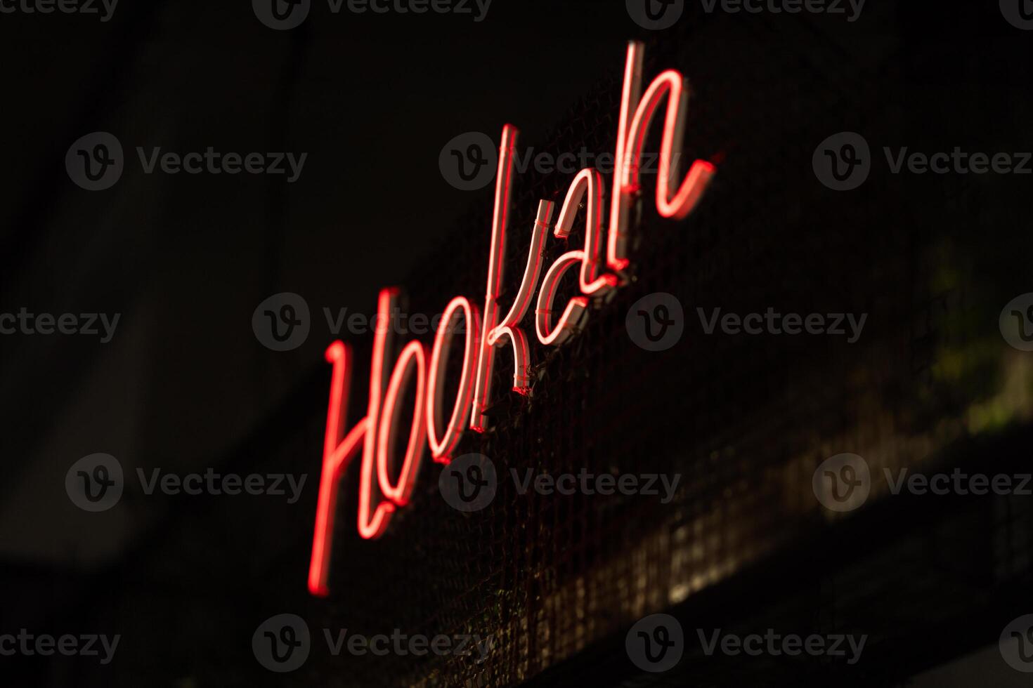red neon sign hookah place in hookah bar, tobacco packaging in the foreground photo