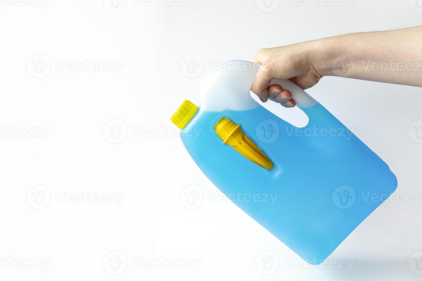 Male hand holding a bottle of antifreeze additive water-based liquid, on white background. photo
