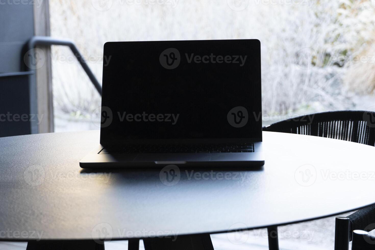 laptop on a round table with an outdoor background. Mockup design, for business, remote work, or modern workspace themes. photo