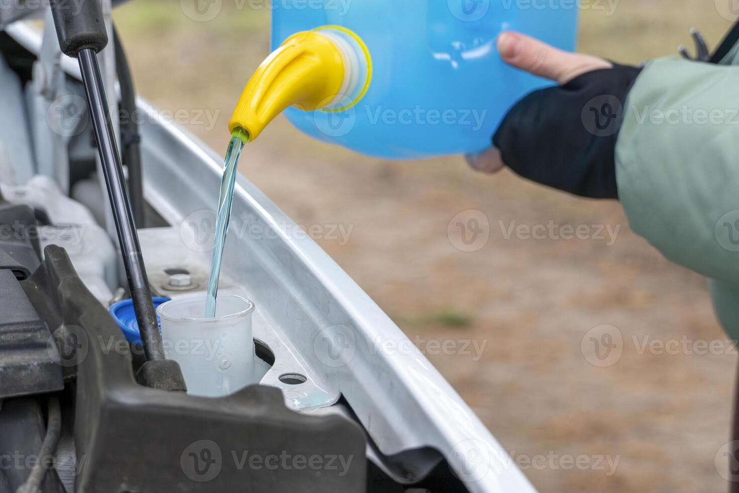 Filling a windshield washer tank with an antifreeze photo