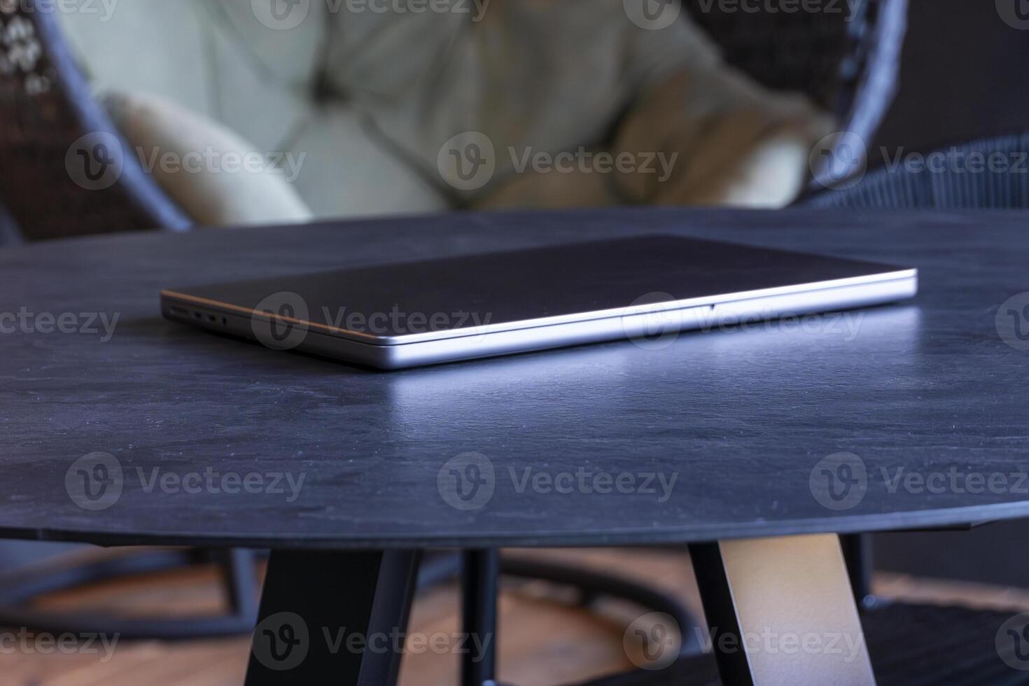 laptop on a round table with an outdoor background. Mockup design, for business, remote work, or modern workspace themes. photo