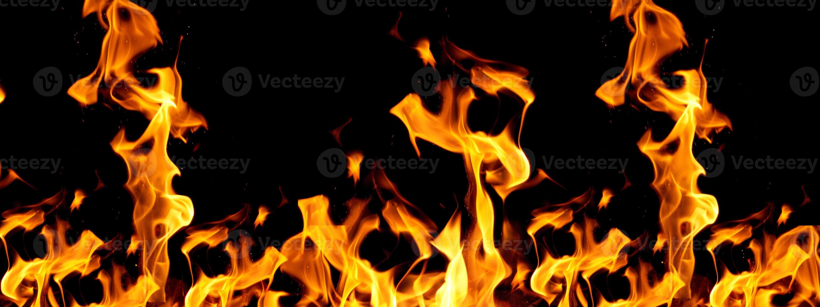 Tongues of bright flame rising upwards against a black background, creating the effect of movement and warmth photo
